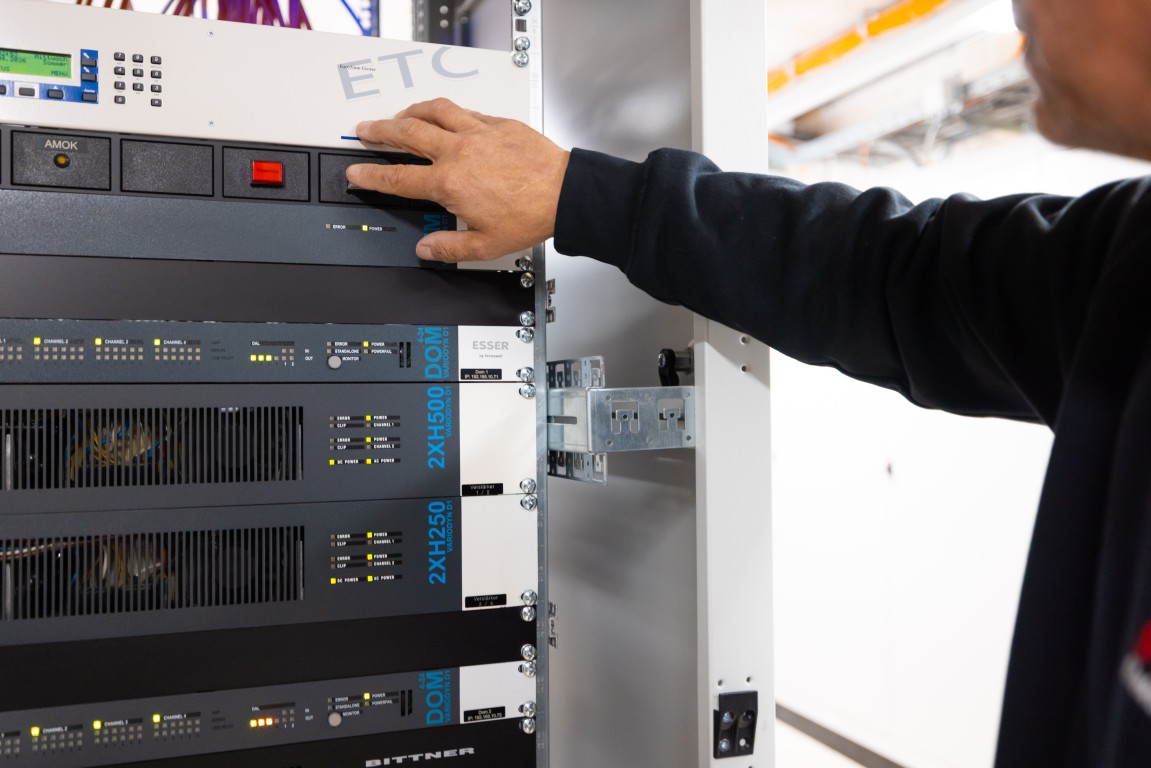 Hand am roten Schalter eines Technik-Racks in einem Zürcher Gewerbebau