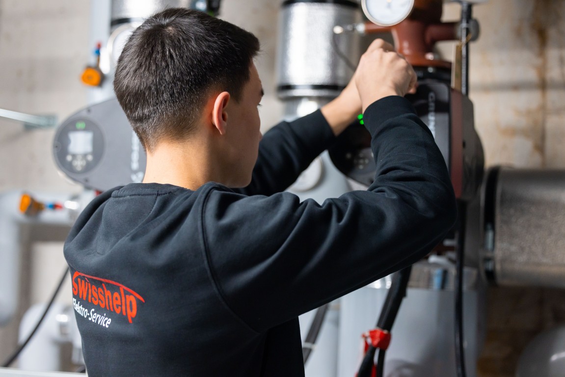 Monteur von Swisshelp Elektro arbeitet an der Haustechnik im Technikraum