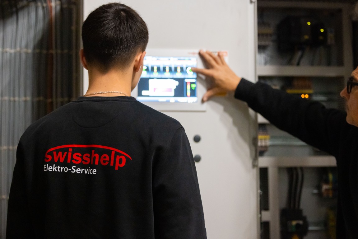 Swisshelp-Techniker bedient Smart Home Touchpanel mit Heizungssteuerung