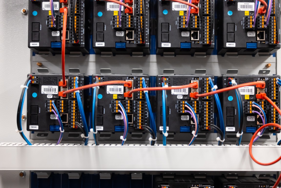 Netzwerkmodule mit roten Patchkabeln im offenen Schaltschrank
