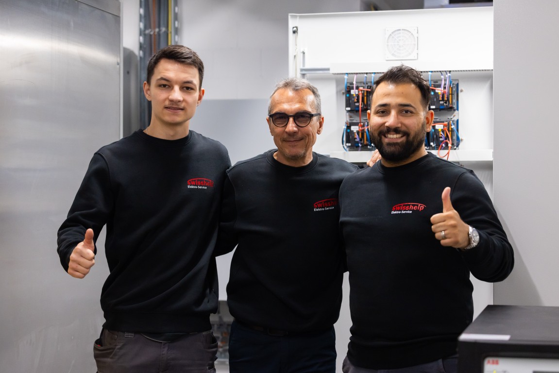 Drei Monteure von Swisshelp Elektro zeigen am Standort Weiningen den Daumen nach oben