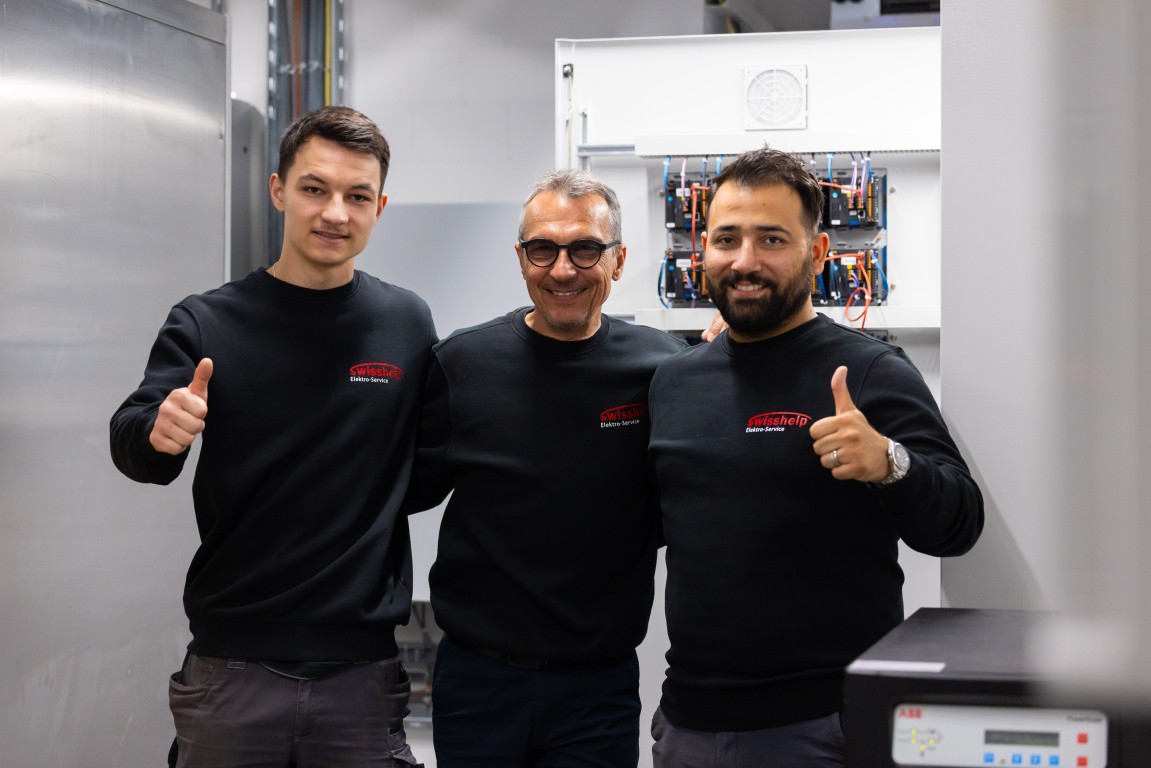 Swisshelp Team zeigt Daumen hoch nach abgeschlossener Elektrokontrolle in Zürich