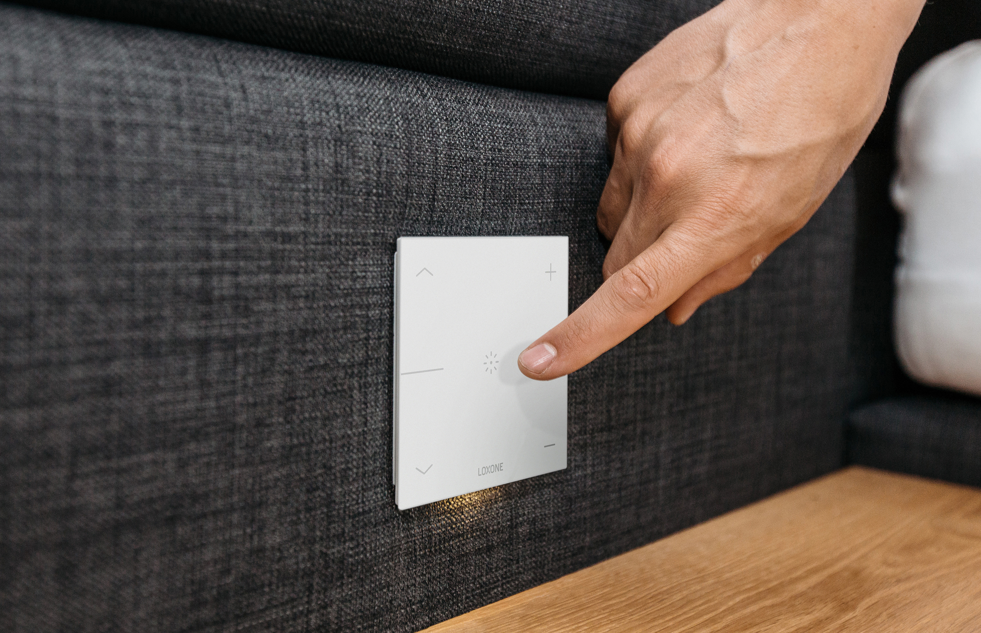 Loxone-Taster an einem Sofa mit Handbedienung